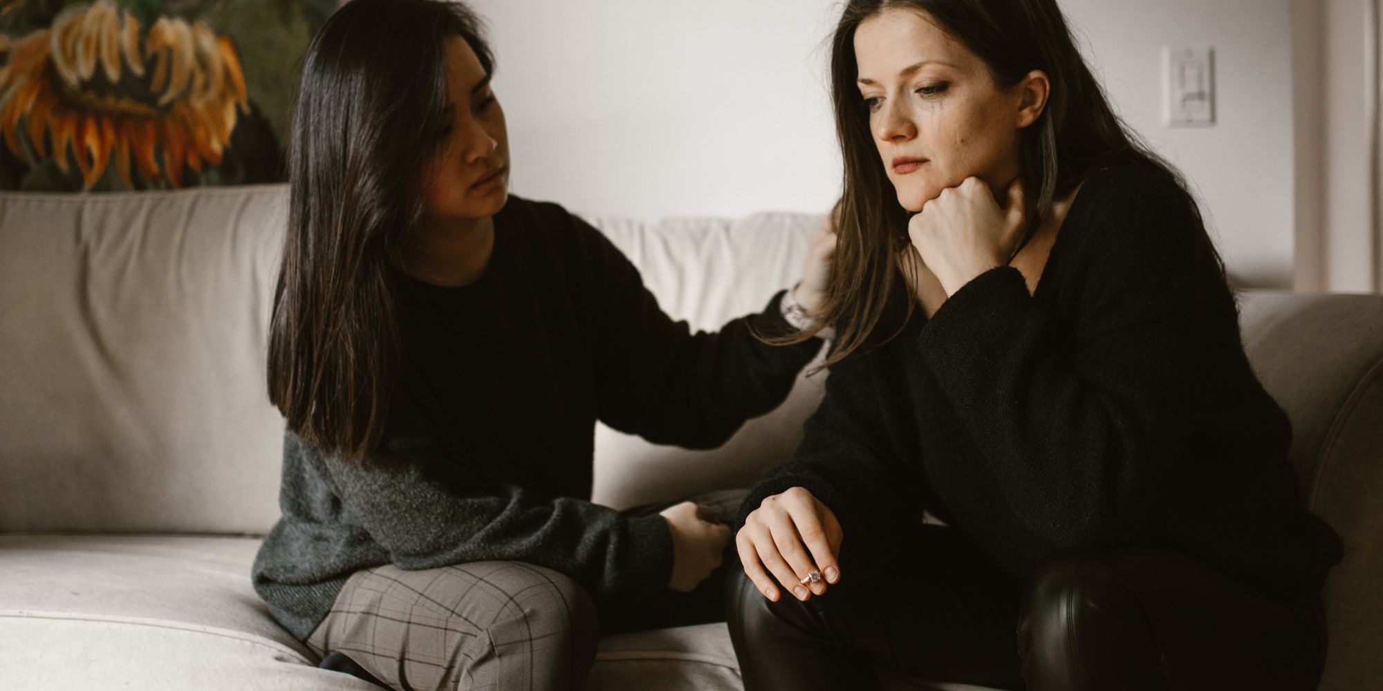 Woman comforting a friend on a sofa, showing emotional support on World Mental Health Day